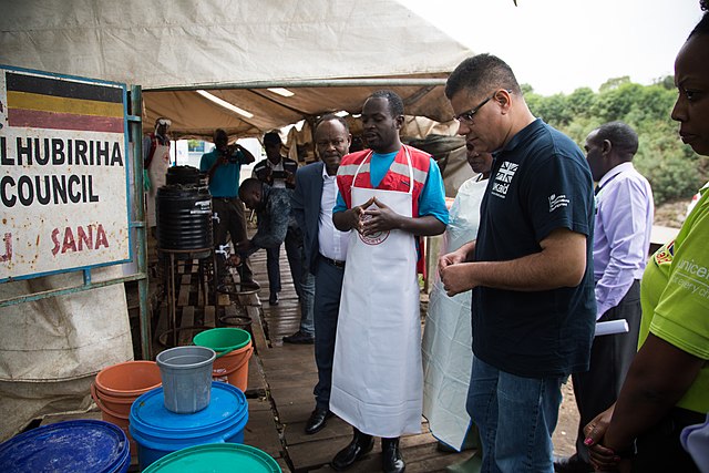 A group of people, including healthcare workers, examining sanitation supplies at an Ebola preparedness site in Uganda.